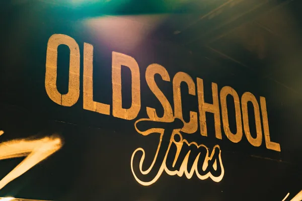 The Old School Jim's name hand-painted in gold on a black wall